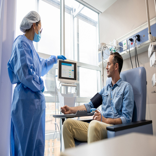 Oncology nurse checking the vital signs of a chemotherapy patient at the hospital - cancer treatment concepts